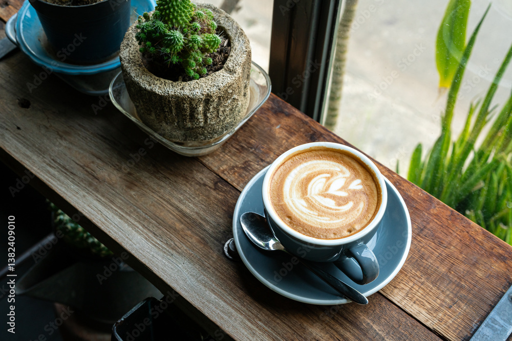 Hot coffee latte with latte art milk foam in cup mug on wood desk on top view. As breakfast In a coffee shop at the cafe,during business work concept,vintage style