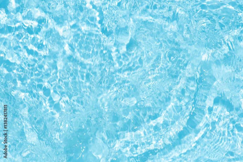 Obraz premium Blue water with ripples on the surface. Defocus blurred transparent blue colored clear calm water surface texture with splashes and bubbles. Water waves with shining pattern texture background.