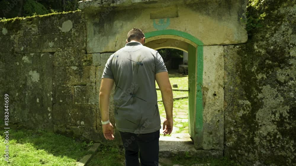 A tourist goes through a narrow entryway to visit the mausoleum of the Alevian saint Demir Baba Teke located in the municipality of Isperih, Razgrad province in Bulgaria. A tourist goes through a narrow entryway to visit the mausoleum of the Alevian saint Demir Baba Teke located in the municipality of Isperih, Razgrad province in Bulgaria.
