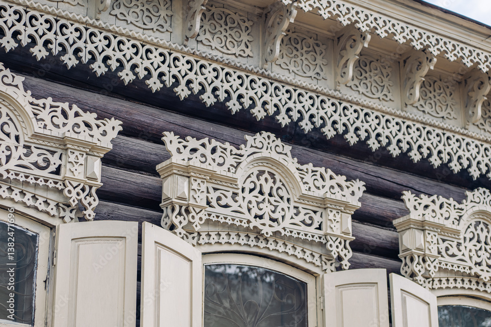 Fototapeta premium Intricate carvings embellish the window frames of a historic wooden house, showcasing the rich heritage of russian architecture