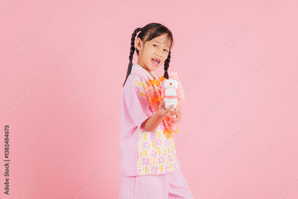 Songkran fun with a happy girl in a floral shirt holding a toy water gun Songkran fun with a happy girl in a floral shirt holding a toy water gun