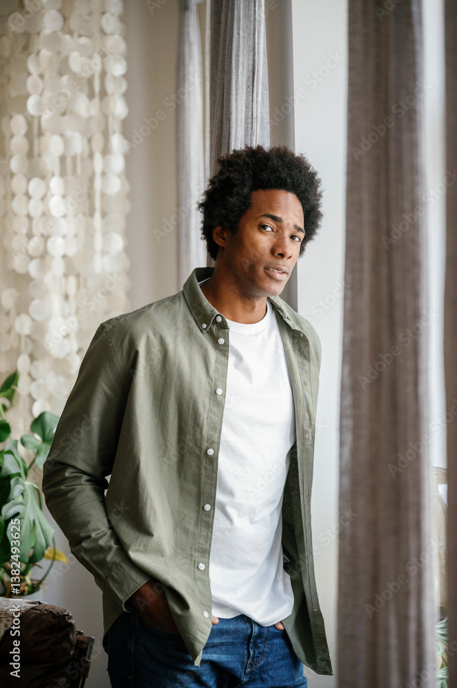 Confident man standing with hand in pocket at home Confident man standing with hand in pocket at home