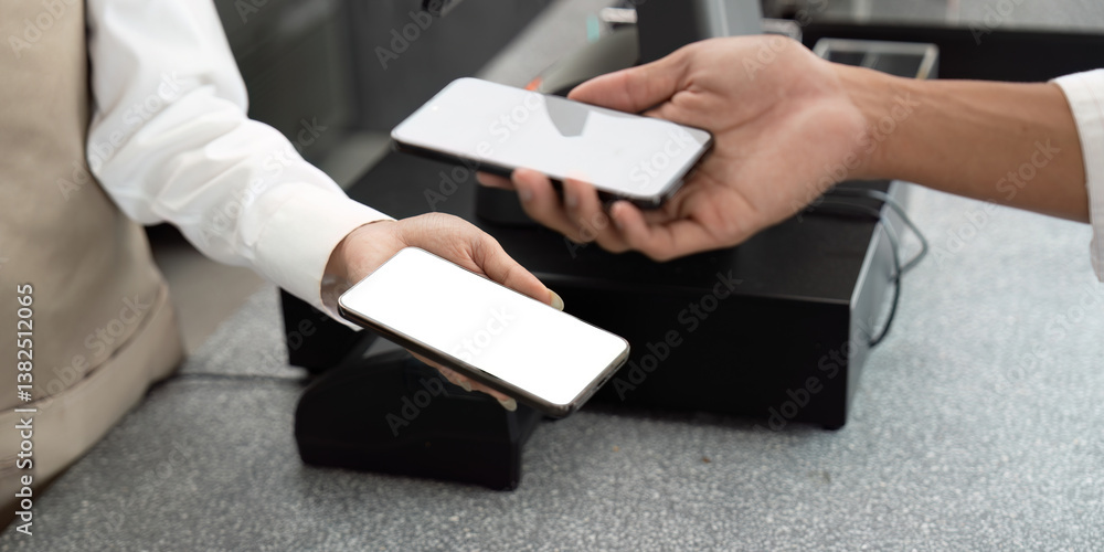 Contactless Payment and Technology. A customer using a mobile device to make a contactless payment at the register. Contactless Payment and Technology. A customer using a mobile device to make a contactless payment at the register.