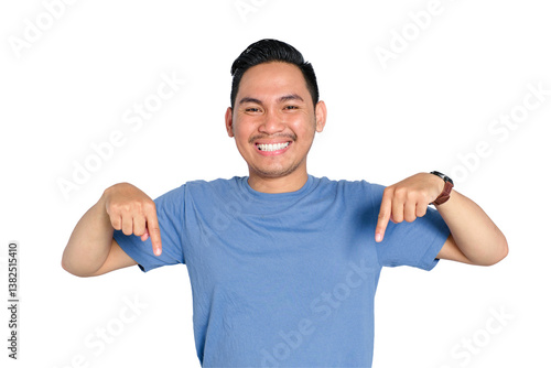 Happy young Asian man smiling and pointing downward with both hands, wearing casual blue t-shirt, isolated on transparent background