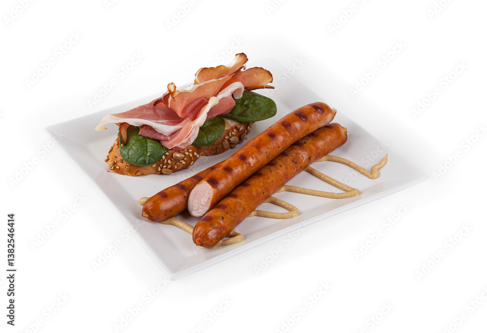 Fried eggs with sausages and croissants on white plate