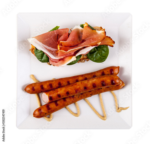 Fried eggs with sausages and croissants on white plate