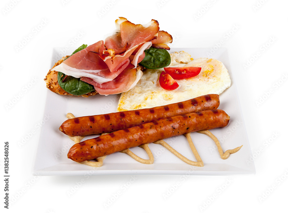 Fried eggs with sausages and croissants on white plate