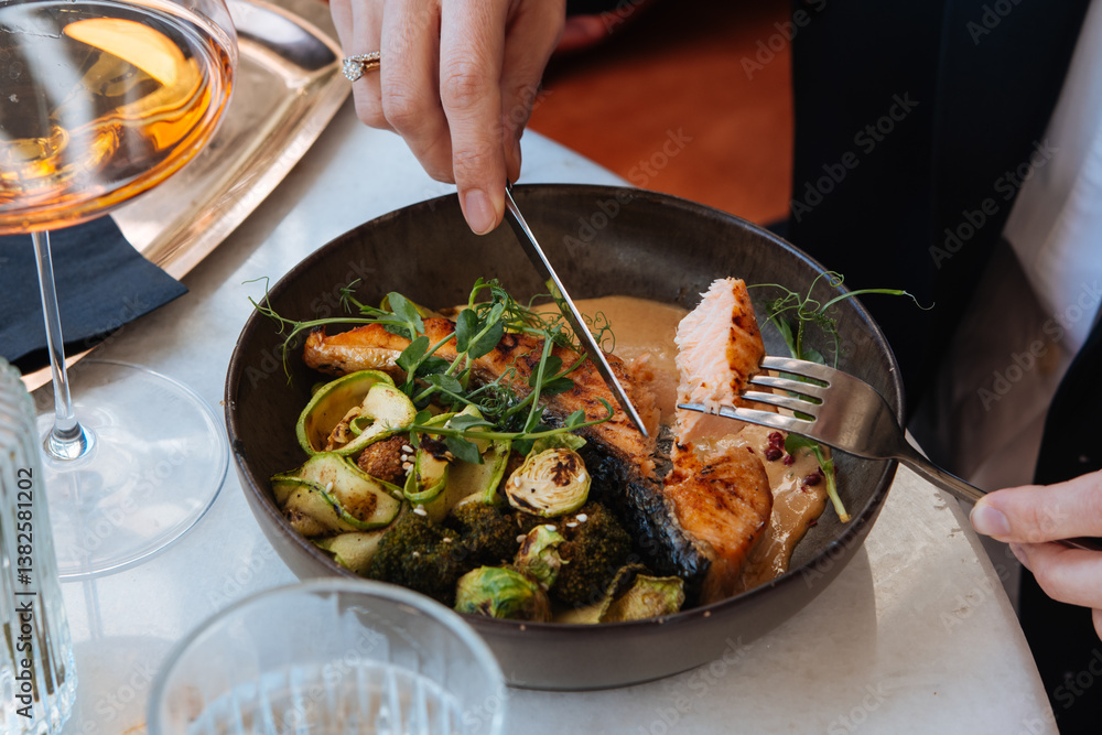 Grilled salmon with brussels sprouts and broccoli served for a dinner in a restaurant.