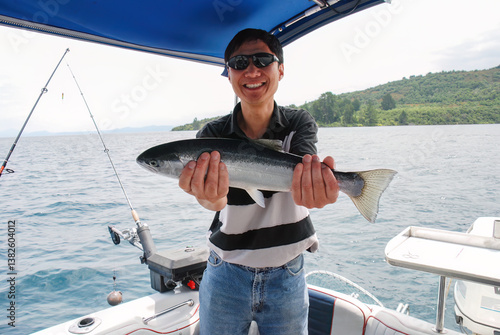 Smiling man holding a caught trout. Lake Taupo. New Zealand.