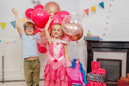 Obraz na płótnie Happy kids in playful outfits, hold above heads festive balloons w salonie
