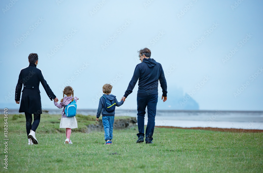 Family of travelers walk with famous castle in the mist ahead