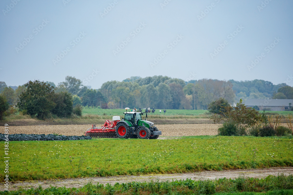 Tractor is seen cultivating the autumn field in Normandy, France
