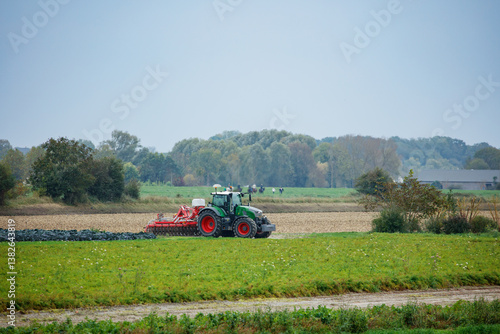 Obraz na płótnie Tractor is seen cultivating the autumn field in Normandy, France w salonie