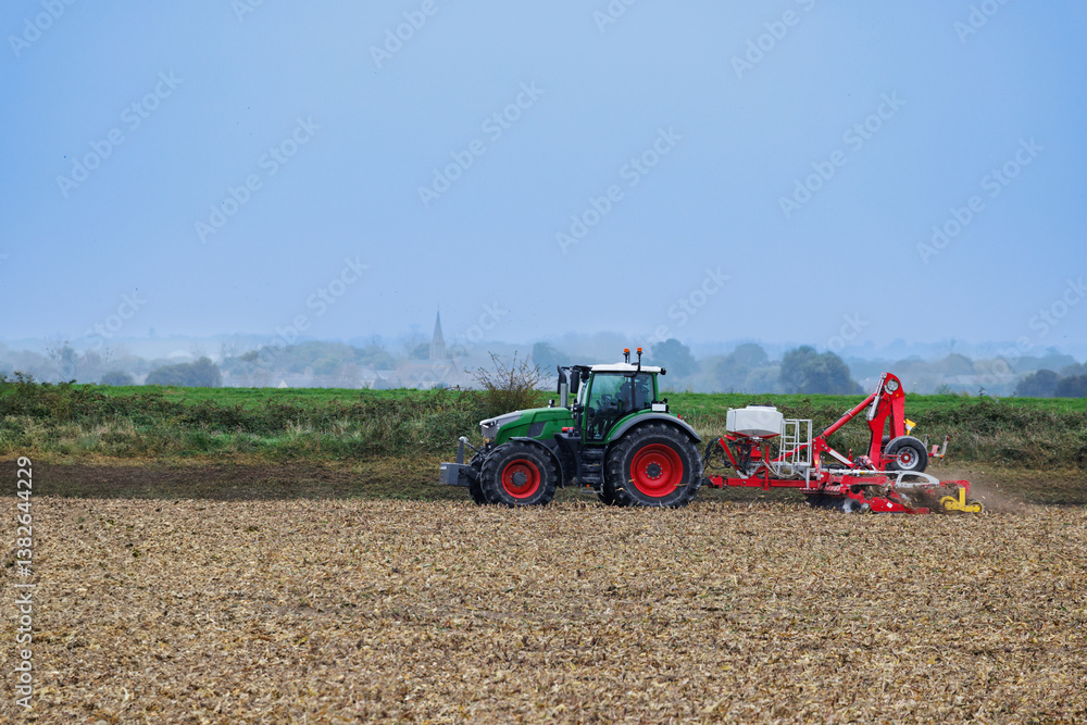 Tractor in Normandy countryside, cultivating the field, France