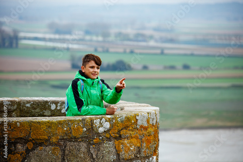 Obraz na płótnie A boy pointing from stone lookout tower of Mont Saint Michel w salonie