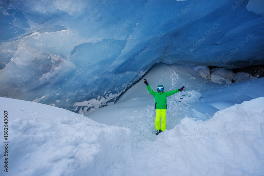 Adventurer skier stand in icy blue cave, admire wonder of nature