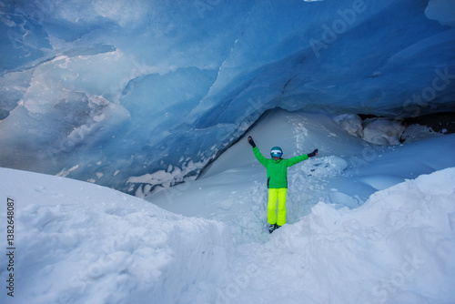 Obraz na płótnie Adventurer skier stand in icy blue cave, admire wonder of nature w salonie