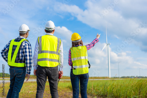 Three engineers working in the clean energy and wind sectors are seen discussing industry projects, wearing safety gear, using walkie-talkies and tablets to coordinate field operations.