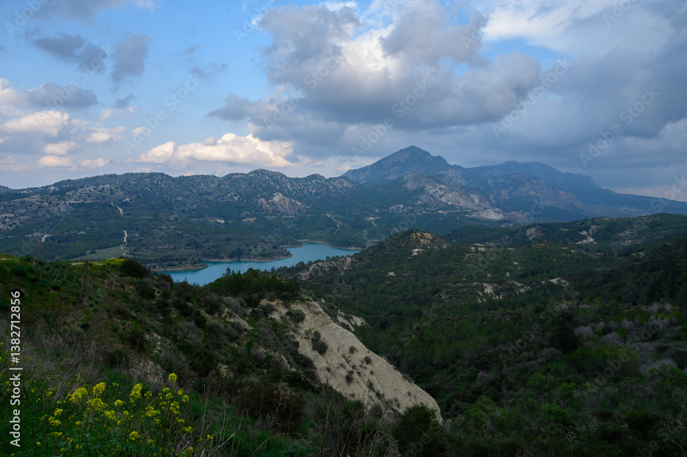 Majestic mountain landscape with serene lake under a cloudy sky during late afternoon in rural countryside Majestic mountain landscape with serene lake under a cloudy sky during late afternoon in rural countryside