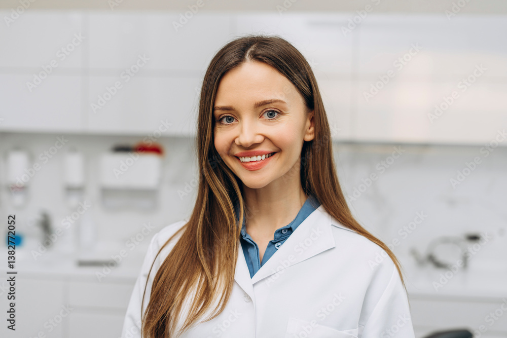 Happy young female dentist wearing uniform posing at camera in her office Happy young female dentist wearing uniform posing at camera in her office