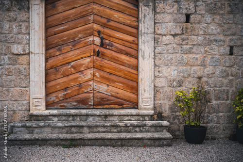 Obraz na płótnie Stone wall of mediterranean house with vintage wooden door and potted plants w salonie