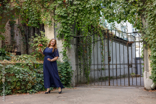 Obraz na płótnie Woman in a long blue dress in the garden. w salonie