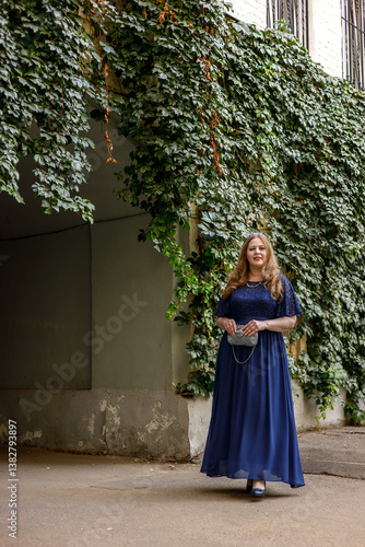 Obraz na płótnie Woman in a long blue dress in the garden. w salonie
