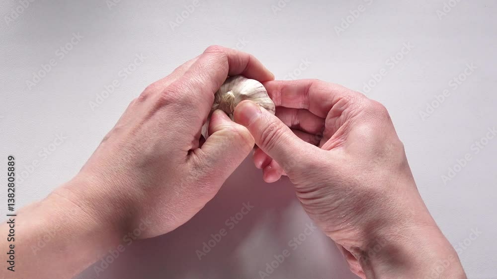 Two Hands Peeling Garlic. Cooking Ingredient Preparation. Peeling Garlic Cloves by Hand. Food Preparation Process.
Two Hands Peeling Garlic. Cooking Ingredient Preparation. Peeling Garlic Cloves by Hand. Food Preparation Process.