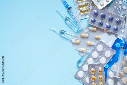 Variety of medications and syringes on blue background for healthcare and medical use