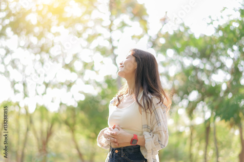 Wallpaper Mural Asian woman enjoying summer while breathing fresh air in sunny park, feeling relaxed and happy amidst lush greenery. Wellness lifestyle concept. Torontodigital.ca