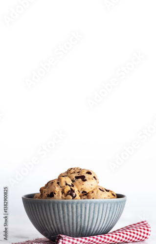 Photograph of a bowl filled with homemade cookies on a white background. Minimalist and bright composition, perfect for illustrating homemade baking, sweet snacks, and food photography.