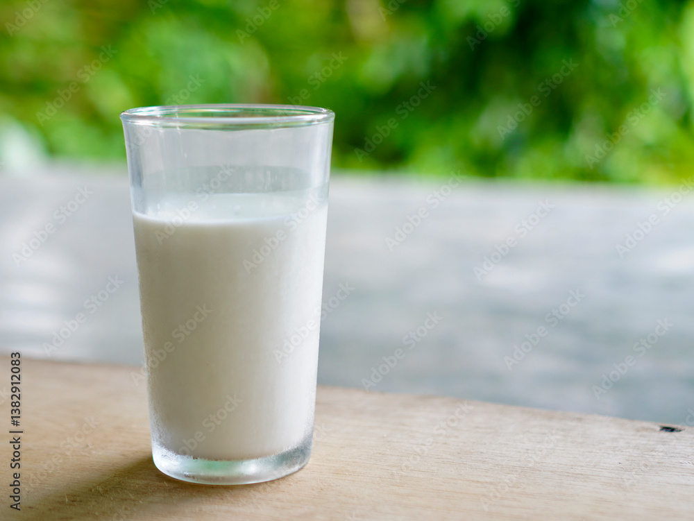 A glass of milk stands on a bokeh background. Fresh milk for healthy life