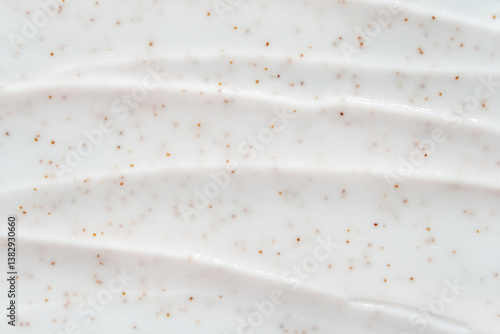 Smooth white cream texture with exfoliating brown specks for skincare and beauty products.