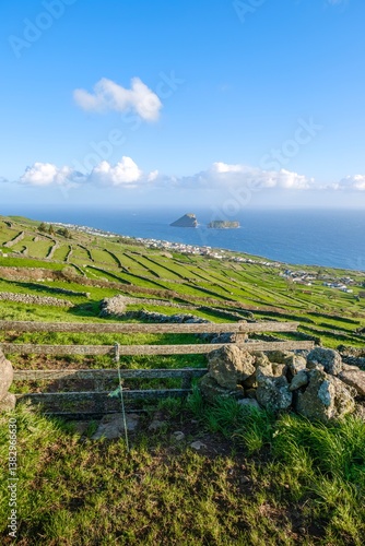 Obraz na płótnie A stunning panoramic view of Terceira, Azores, showcases the island unique rural landscape with its green fields, stone walls, wood fence, and a picturesque coastal vista w salonie