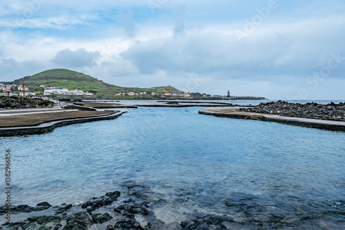 A stunning view of natural rock pools in Terceira, Azores, where the ocean meets the rugged volcanic coastline, creating a unique swimming spot
