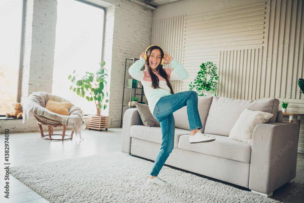 Smiling young girl enjoying music in a cozy living room with bright afternoon daylight surroundings Smiling young girl enjoying music in a cozy living room with bright afternoon daylight surroundings