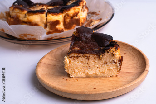 basque burnt cheesecake on wood plate on white background