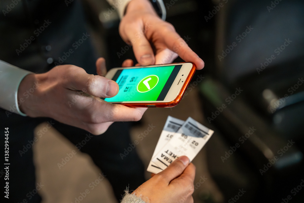 Usher checking online tickets on smartphone at cinema entrance