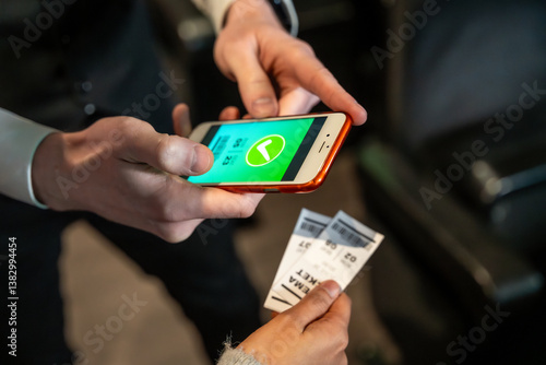Usher checking online tickets on smartphone at cinema entrance
