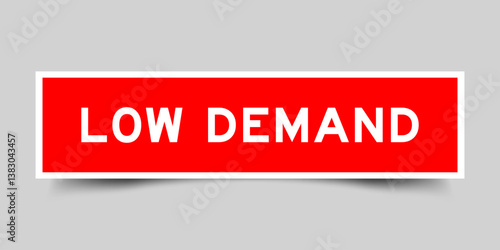Red color square shape sticker label with word low demand on gray background