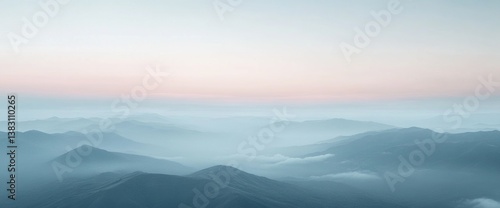 Serene pastel sunrise over misty mountain ranges, creating a tranquil and ethereal landscape.