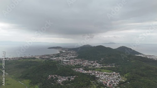 Exploring coastal town views from hills with dramatic cloud cover