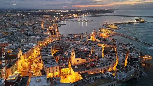 Embankment and old town with city lights in Molfetta. Aerial evening view of historic center of Molfetta, in the province of Bari, Puglia 