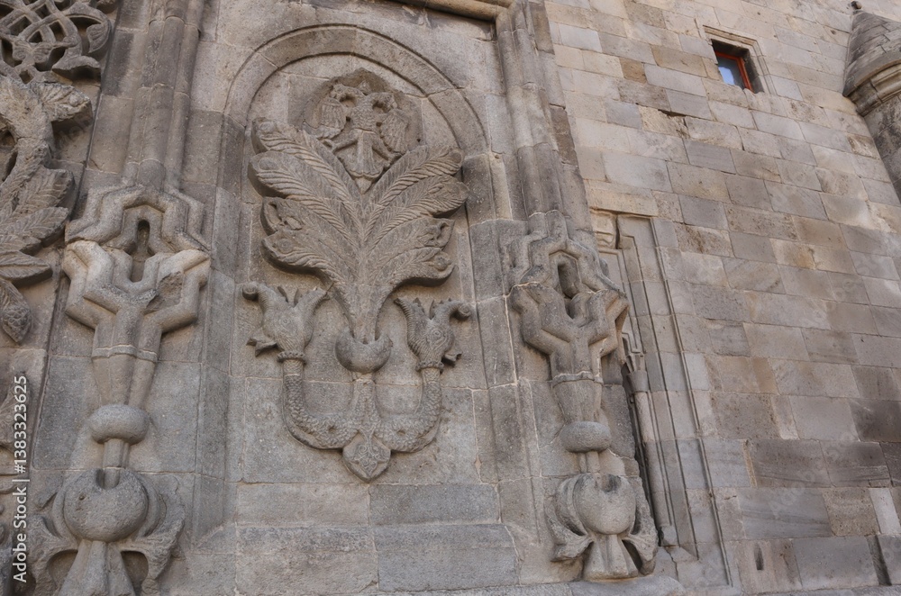 Erzurum, Turkey. Stone carvings on Twin Minaret Madrasa’s exterior wall, featuring floral motifs and the iconic double-headed eagle— a stunning Seljuk architectural masterpiece. Erzurum, Turkey. Stone carvings on Twin Minaret Madrasa’s exterior wall, featuring floral motifs and the iconic double-headed eagle— a stunning Seljuk architectural masterpiece.