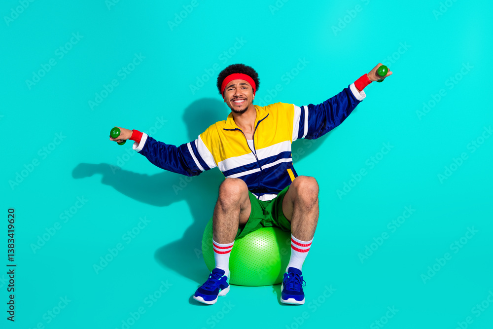 Young sporty man performing workout exercises with a vibrant retro outfit and a cheerful mood against a bright turquoise background. Young sporty man performing workout exercises with a vibrant retro outfit and a cheerful mood against a bright turquoise background.