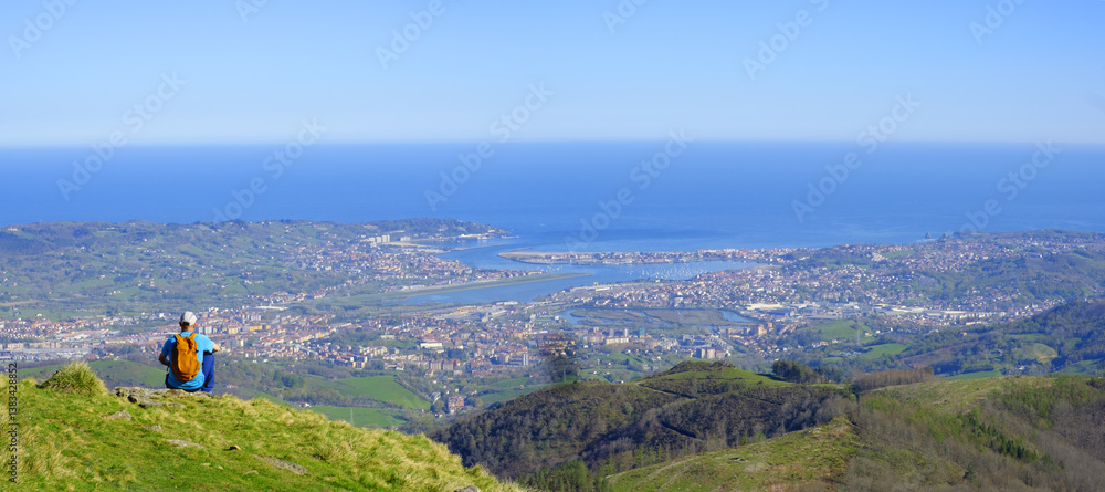 Hiker looking out over the bay of Txingudi, Euskadi