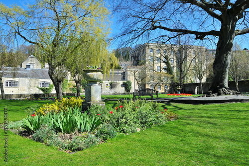 Beautiful green park garden with colourful flowers, lush lawn and leafy trees