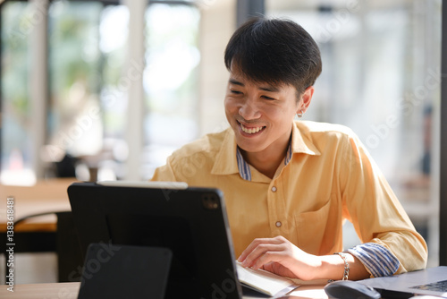 Student studying online and preparing for exams with digital devices and books
