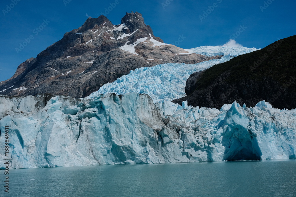 custom made wallpaper toronto digitalAn up-close look at jagged blue ice peaks of a Patagonian glacier, showcasing stunning details of the frozen formations with a mountain in the background. Taken in El Calafate, Argentina