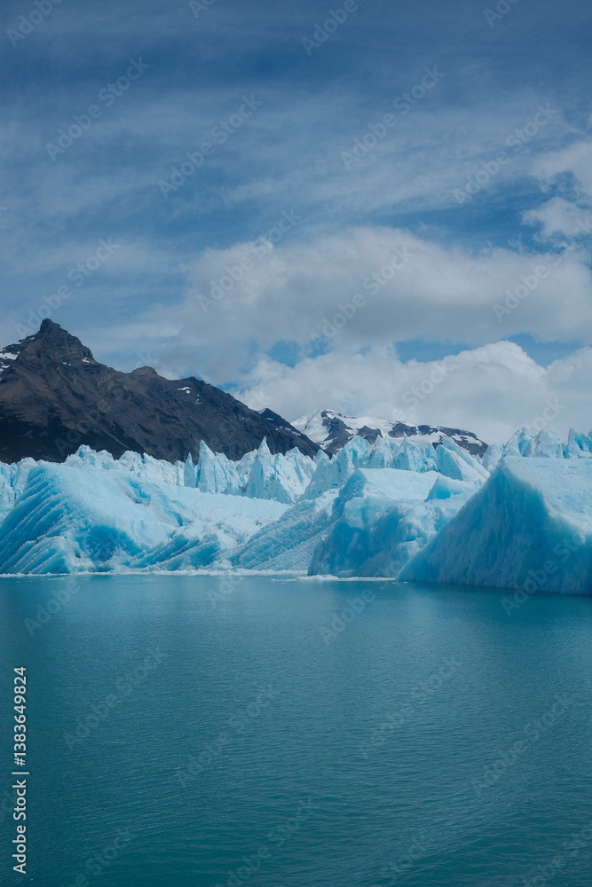 custom made wallpaper toronto digitalClose-up view of Perito Moreno Glacier from a boat tour, showing jagged blue ice walls, turquoise lake water, mountain peaks, and clear blue skies in El Calafate, Patagonia, Argentina.